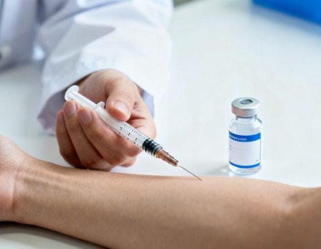 Person receiving a medical injection with a syringe.